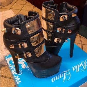 Black platform boots with gold straps and buckles